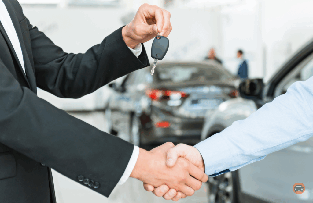 Consumer in car dealership with salesman handing him the keys to a new rebuilt title car. 