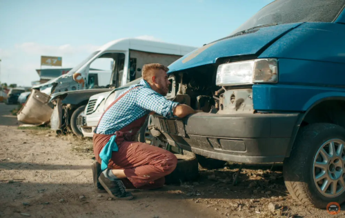 mechanic inspecting the hood of an old car